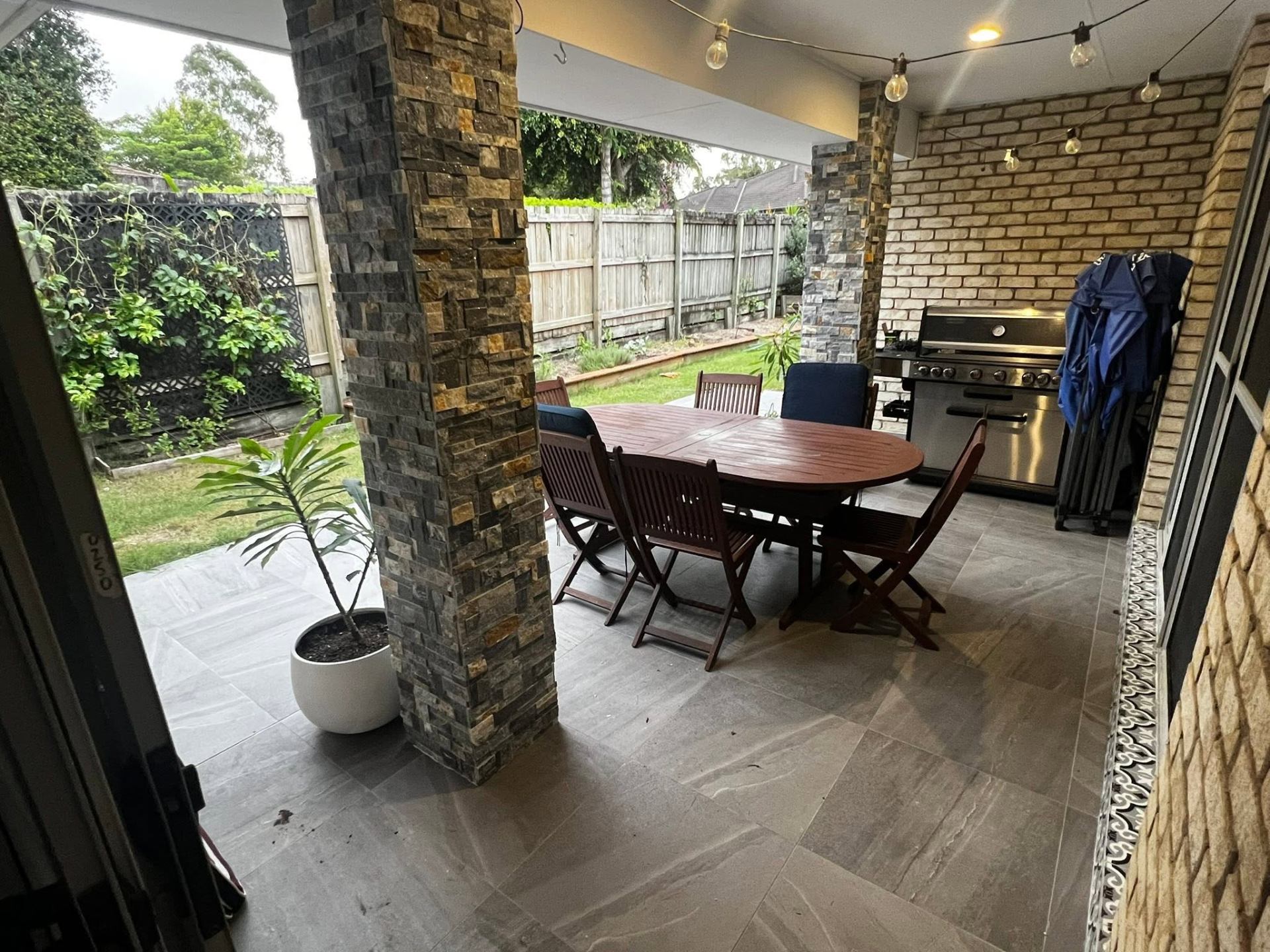 Covered alfresco area with stacked-stone columns and tiled floor